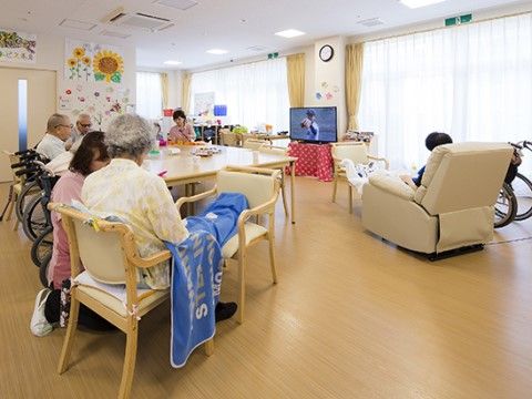 ソファやテレビが置かれている共有スペースでくつろぐ高齢者たち