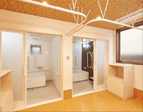 広々とした脱衣所の奥に２つの個浴室が並んで設けられている。着替えやタオルを置ける収納家具が完備されている。