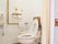 トイレは便座の横のボタンで操作するタイプの温水洗浄便座を設置している。壁には手すりと非常ボタンを取りつけている。