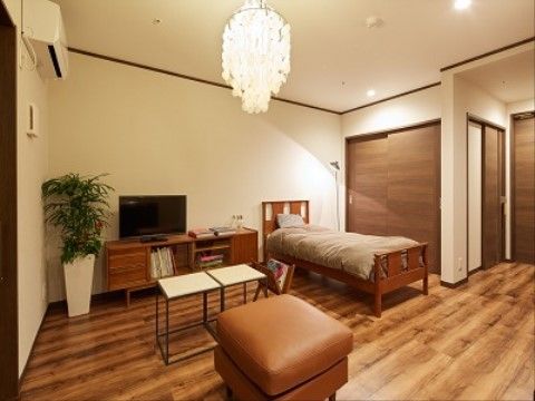 天井にはシャンデリアが吊るされており、木目調の素材が多く使用されたおしゃれな部屋になっている。エアコンが完備され快適に過ごせる。