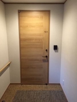 ドアは木目調で色合いが落ち着いた印象を与える。マンションやホテルを思わせるようなモダンなデザインである。