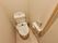 壁際に備えた便座の横側にトイレットペーパーフォルダーと、その上に操作ボタンを設置している。また、安全に備えて縦長の手すりを完備している。