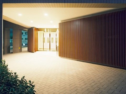 「サービス付き高齢者向き住宅　万葉のさと梶ヶ谷」のエントランス。明かりが灯ったエントランスの夕景。