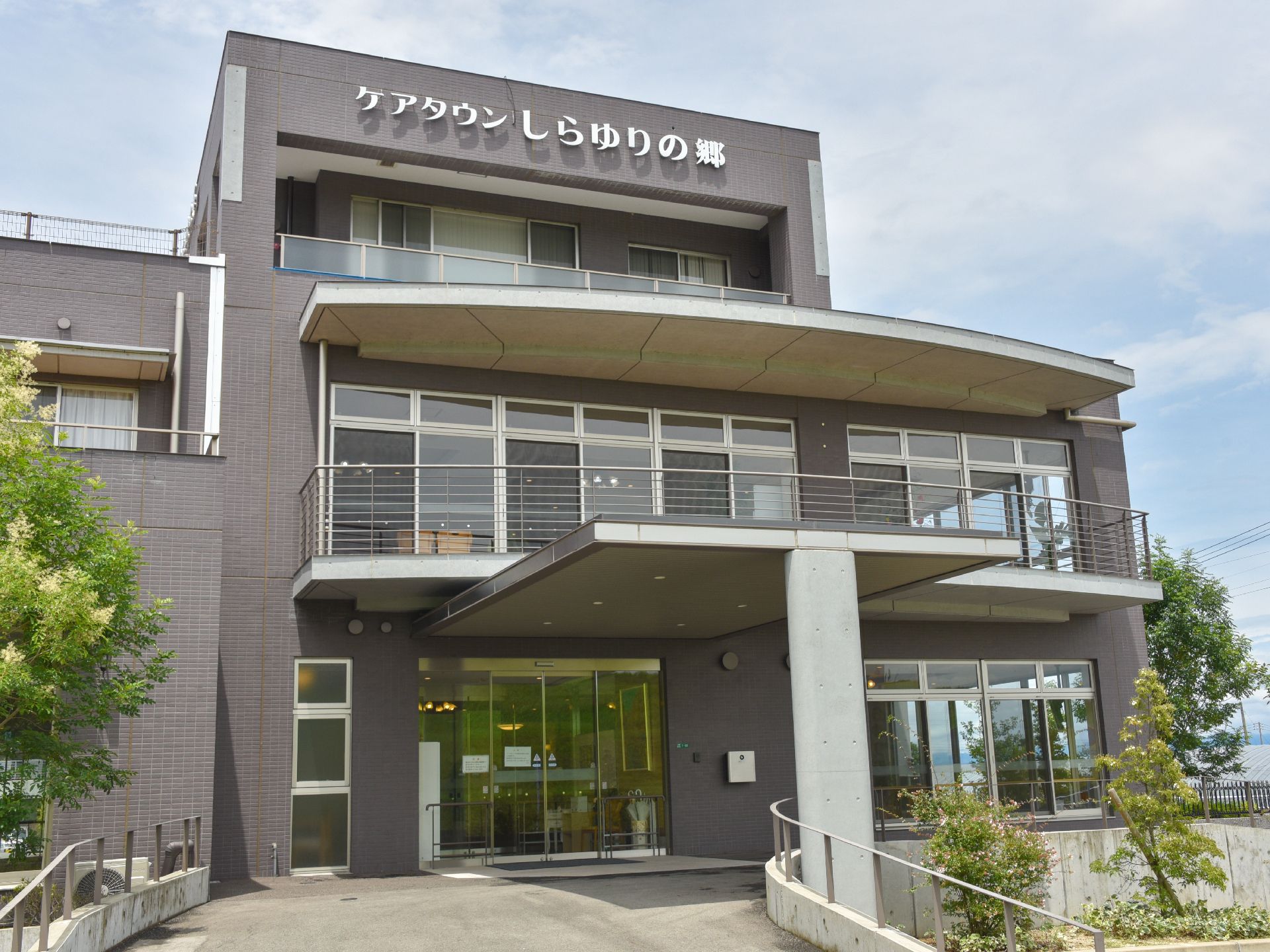 幅広いスロープがあり、スロープにも手すりが設置されている。建物、出入り口は自動ドアでドアもクリアである。