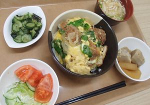 かつ丼とサラダと煮物やきゅうりとワカメの酢の物、スープのセット