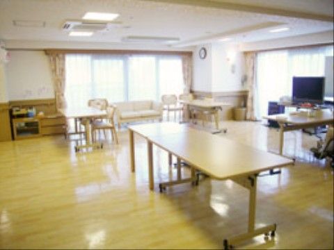 大きな窓にはカーテン、壁には時計がかけられている。キャスター付きのテーブル、椅子、ソファーが用意されている。