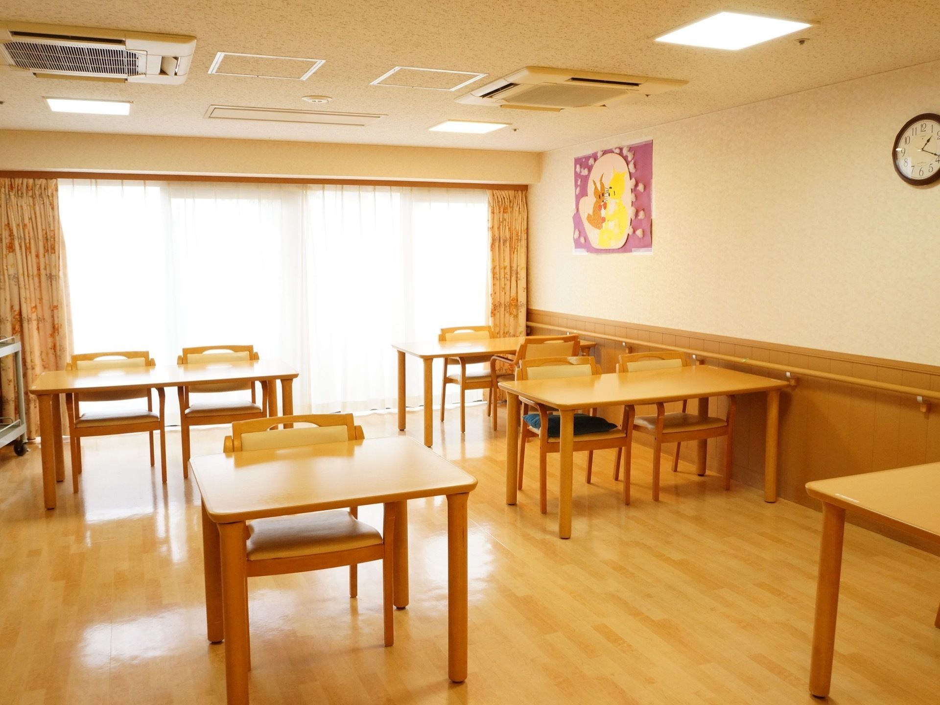 明るく広々とした部屋にテーブルとイスを配置している。車椅子が通れるようにテーブル同士の間隔は広めである。