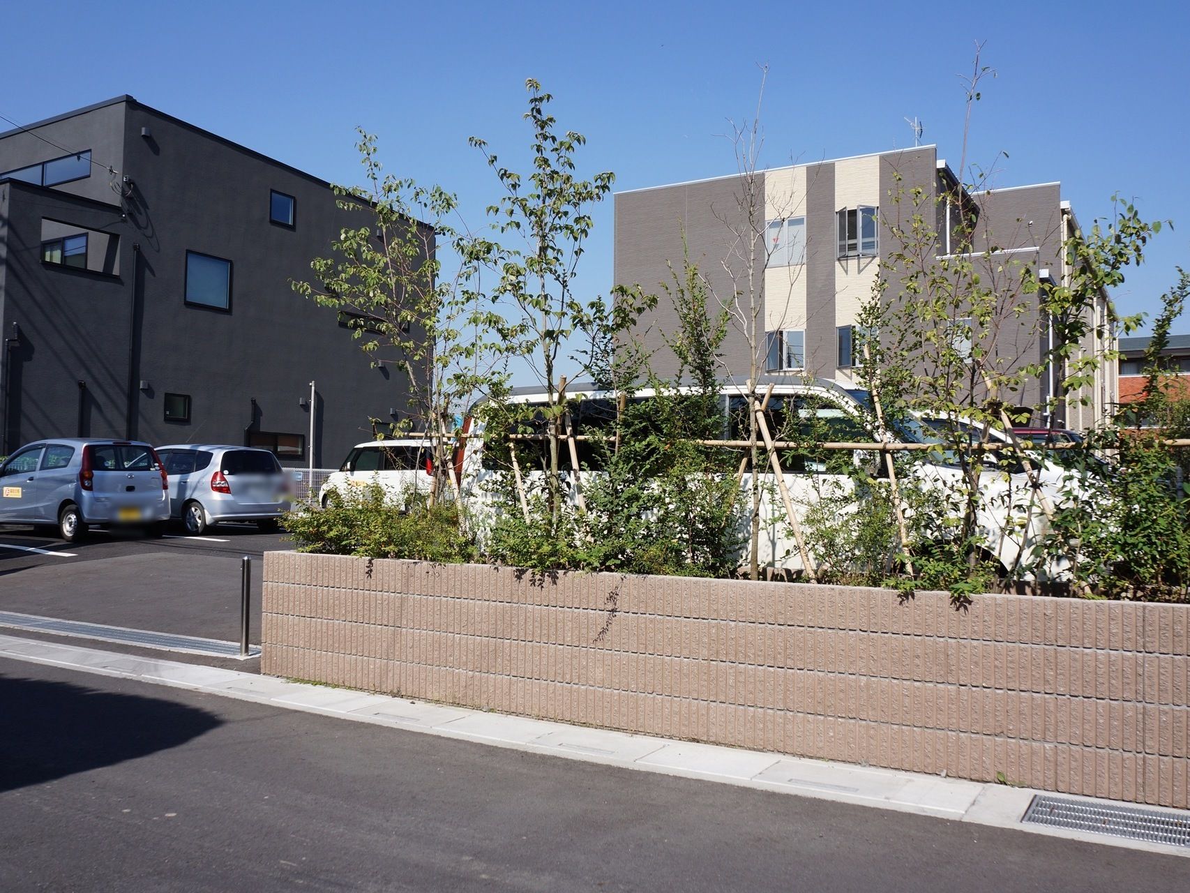 駐車場の入口の隣には植え込みがあり、入口がはっきりとわかる。車は向かい合わせに駐車する。1台ごとのスペースは十分ある。