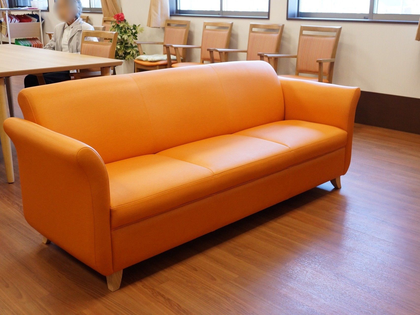 黄色のソファが置かれている。広いのでゆったり座ることができる。フローリングになっており、優しい印象である。