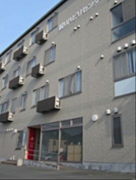 グレーで統一されたマンションのようなデザインである。４階建てで、それぞれの窓にはエアコンの室外機があり、また網戸もついている。