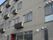 施設建物は３階建てである。グレーの外壁でマンションのような外観になっている。各部屋にはエアコンの室外機が取り付けられている。