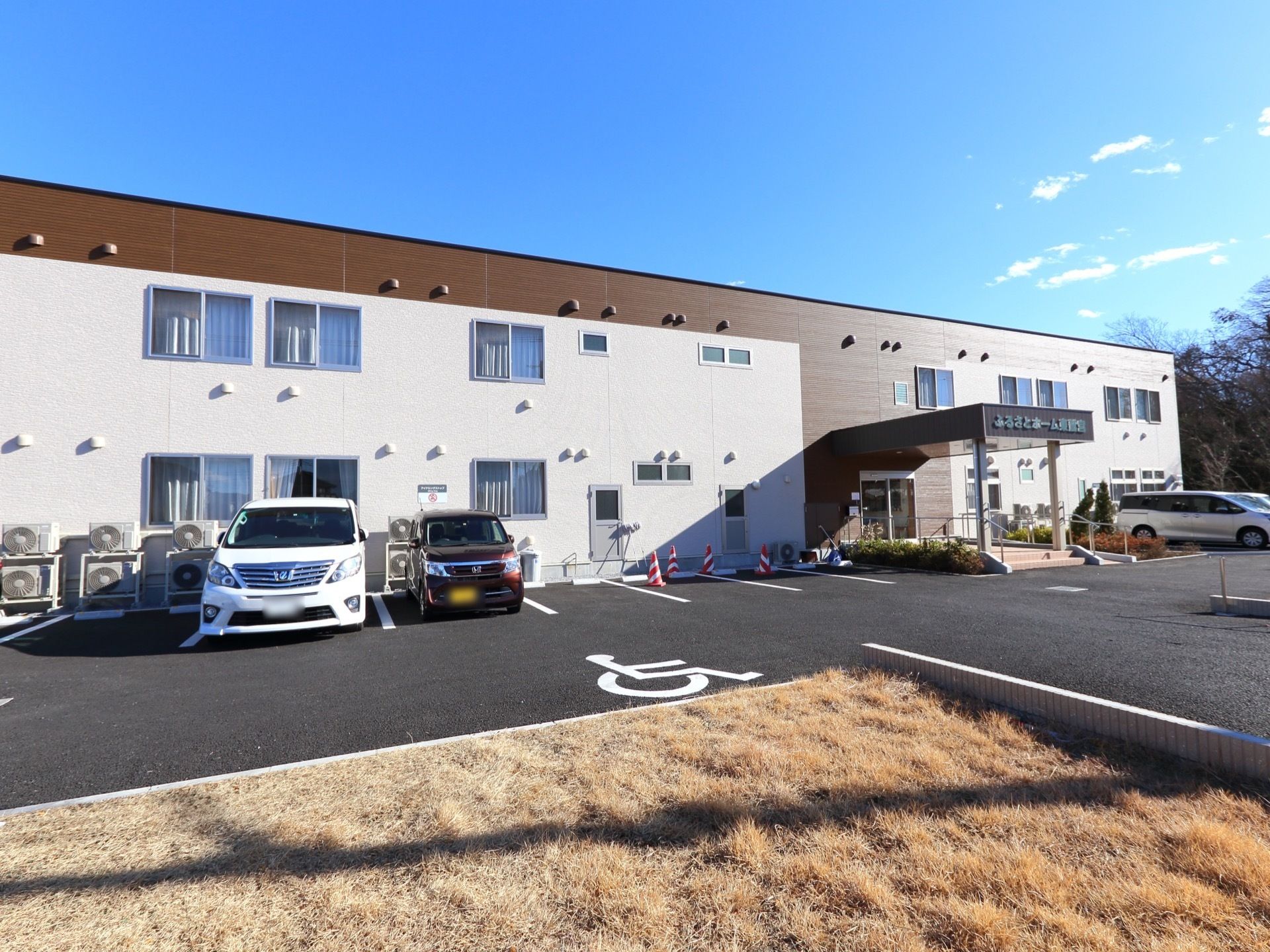 建物は二階建てである。建物の前には、アスファルトで舗装された駐車場がある。玄関ポーチにはひさしが付いている。