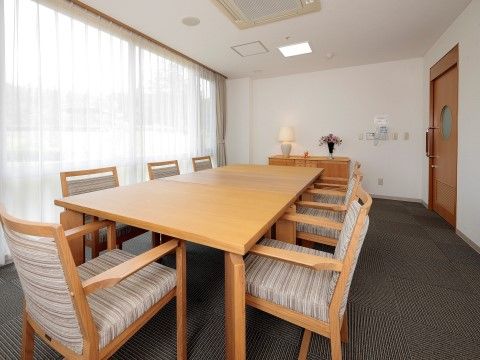 丸い窓がある大きな引き戸を開けると、正面が一面窓になっている。広い部屋の中心には、大きなテーブルを囲んで７脚椅子が並んでいる。