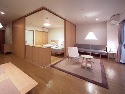 窓がある大きな部屋は、ベッドが２台あるスペースの２辺が、引き戸でが壁になり、閉め切れるようになっている。手前はダイニングセットが置いてある。