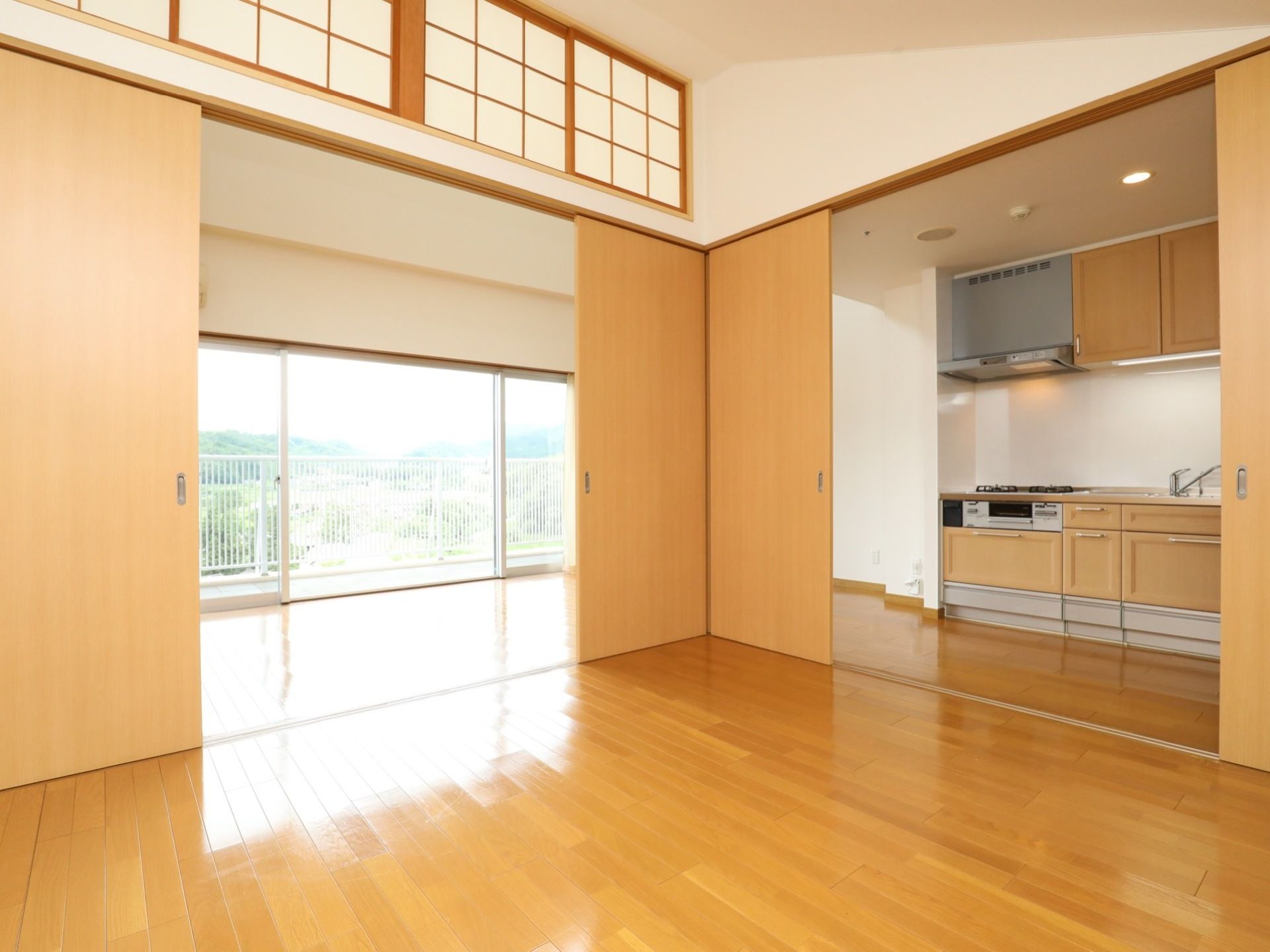 居室はゆったりとした広さがあり、木目調の引戸が取りつけられている。壁際には、キッチンが設置されている。