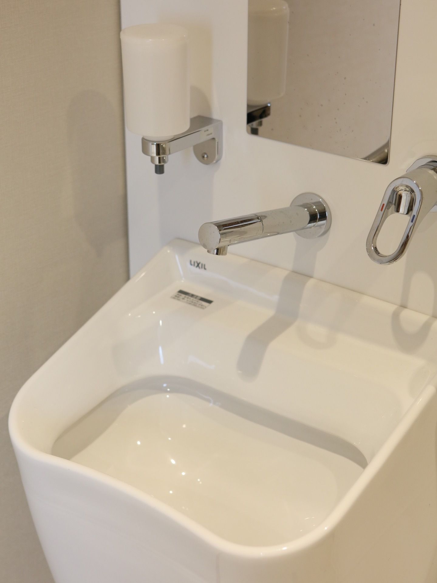 オストメイト対応のトイレになっている。清潔感があり、器具の洗浄をすることができる。前の壁には鏡やハンドソープが設置されている。