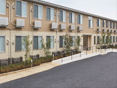 周りを木々で覆われ、緩やかなスロープを上った先にある横長の建物