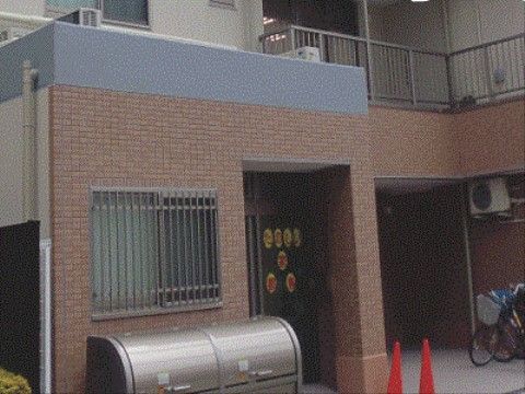 茶色のタイル張りで、自動ドアに文字の書いた紙の貼っている玄関