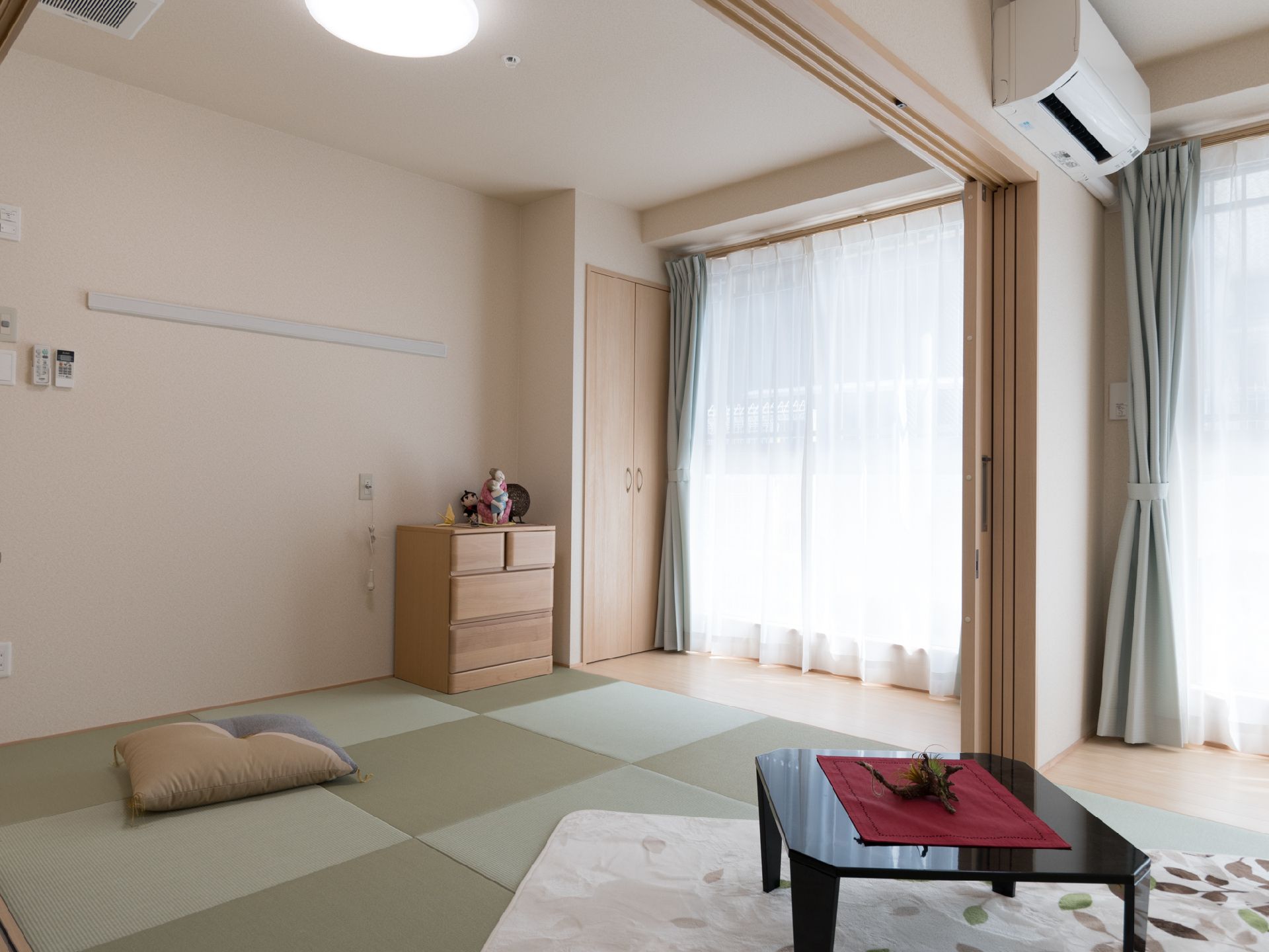 2つ続いている部屋には畳が敷かれている。四角い畳にはへりがなく、市松模様にデザインされている。窓の前はフローリングである。