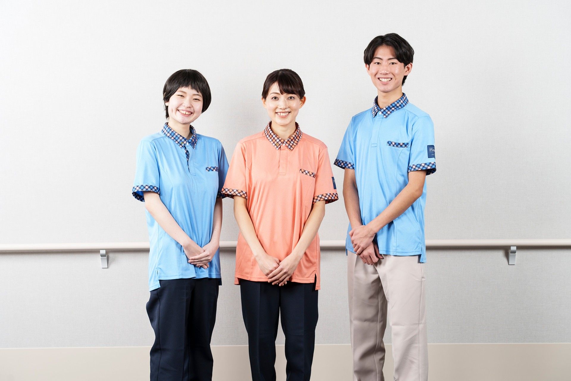 仲良く楽し気に写真に写る、２種類の制服の施設スタッフ