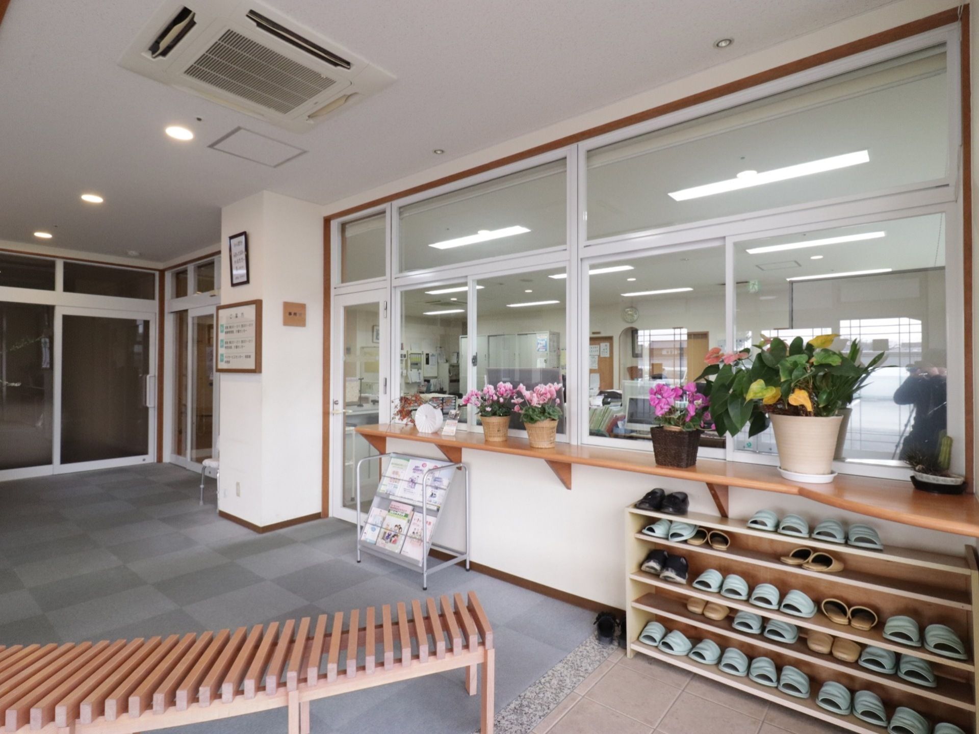 玄関内側には、右手にスリッパ置きと受付が設けられている。カウンターにはお花が置かれており、靴の着脱がしやすいベンチも置かれている。