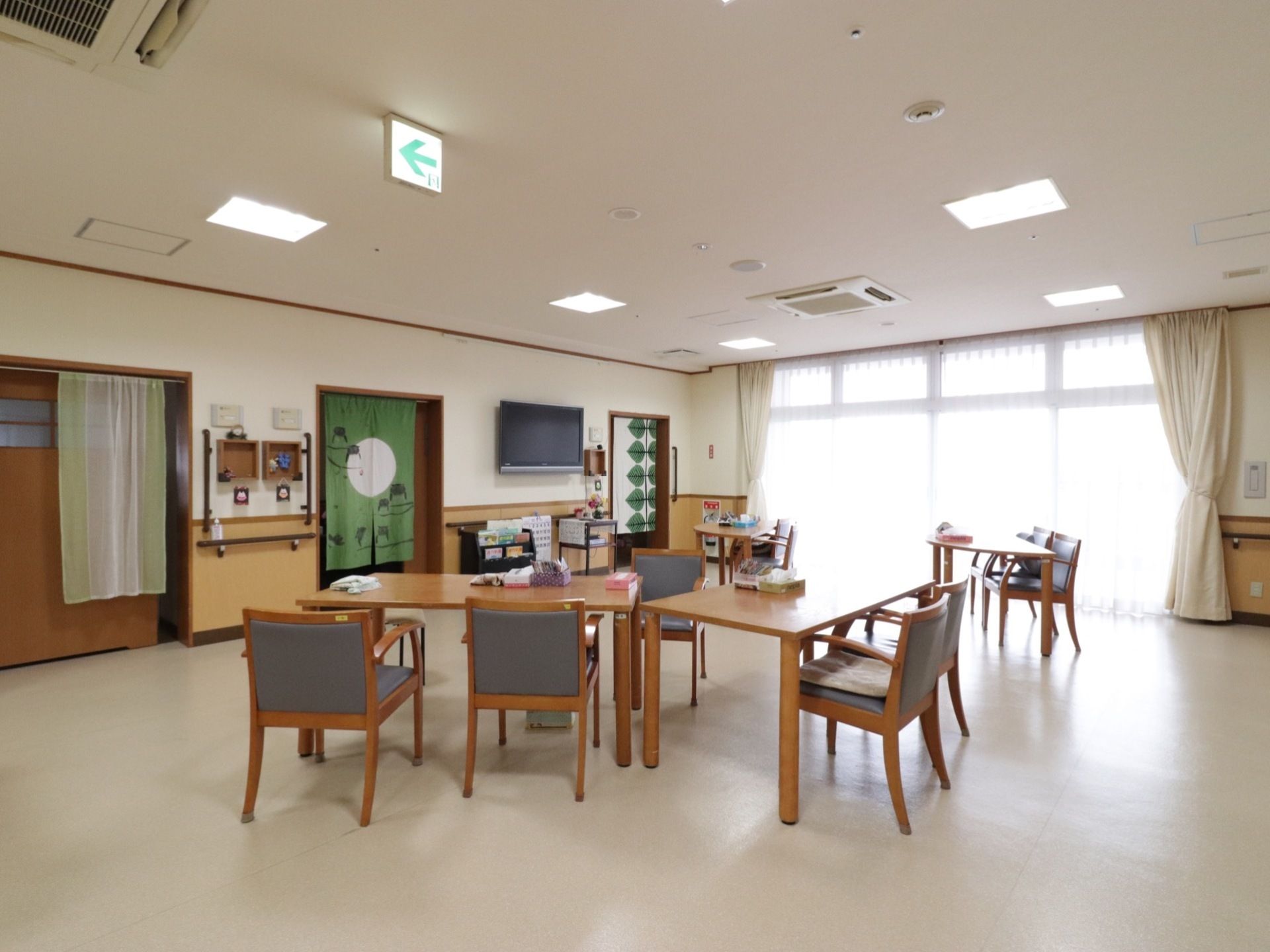 広い食堂は日当たりが良く明るい空間になっている。壁にはテレビが付いている。お部屋を出て直ぐにお食事ができるようになっている。