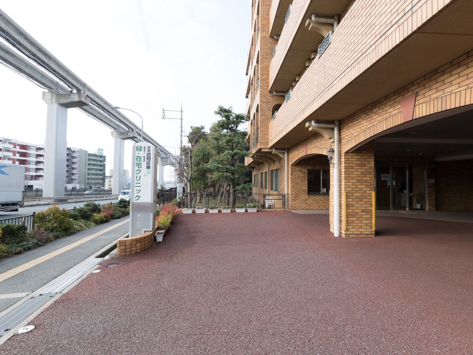 レンガ造りの建物で、高速道路がそばにある。近くにマンションがあり、緑も多く、のどかな住宅街に位置している。