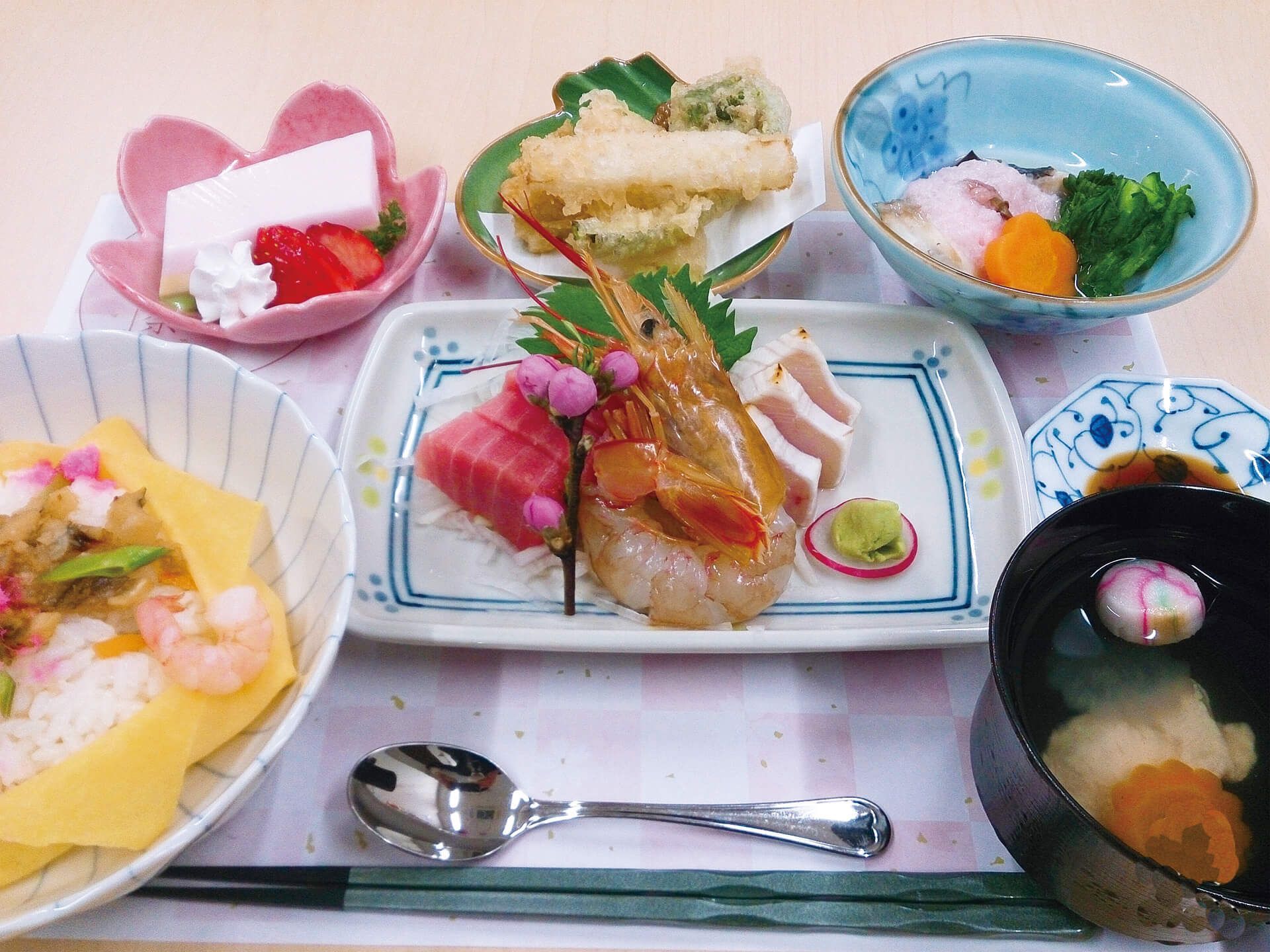 刺身やちらし寿司、お吸い物といったプレートに乗る豪華な食事
