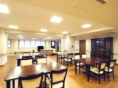 ダークブラウンの重厚なチェストが設置された広いダイニングホール