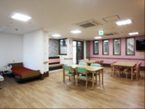 広々とした空間に、ダイニングテーブルと椅子が設置されている。縦長の窓が４つあり、そこの壁だけピンク色になっている。
