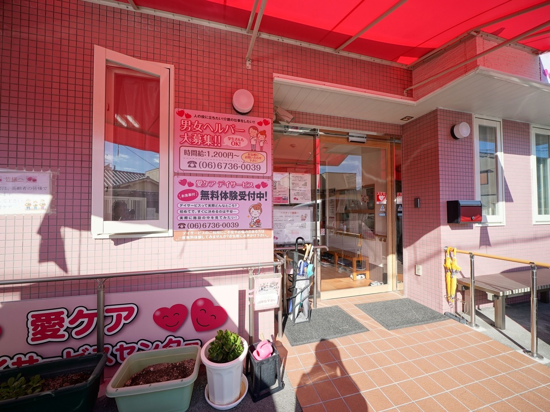 大きな看板が掲げられ、赤い日差し避けのついた施設の入り口