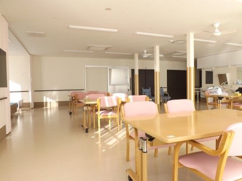 スクエアテーブルや椅子が整列し、窓からの日差しが入る食堂