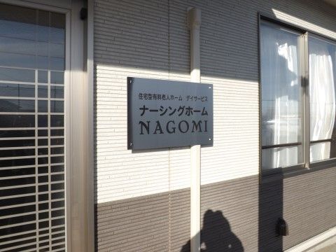 玄関の脇と窓の合間に設置された施設名が書かれた黒い看板