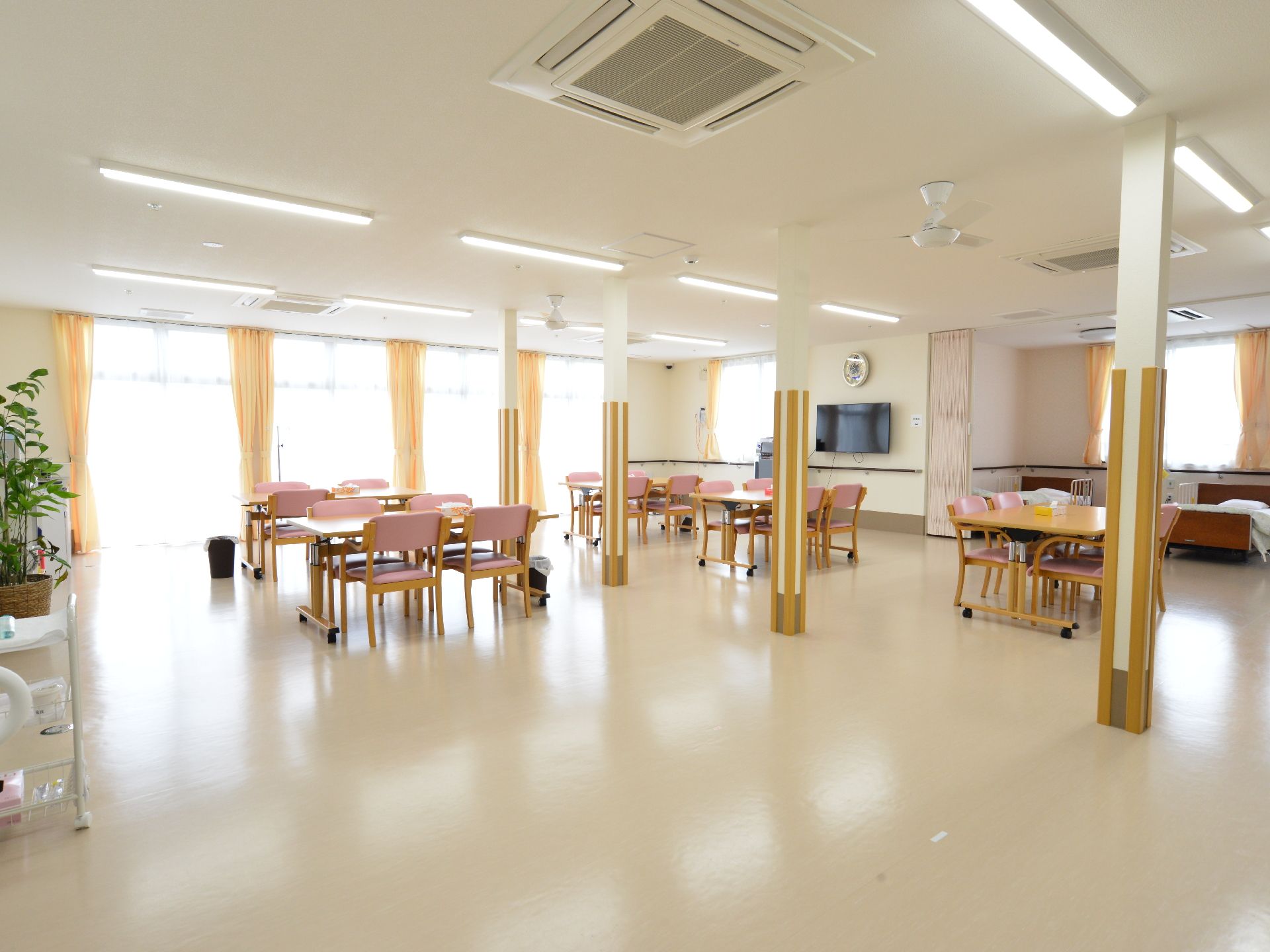 ベランダ式の窓から光が差し込む明るく開放的な雰囲気の共有フロア。テーブルがゆとりをもって配置されている。