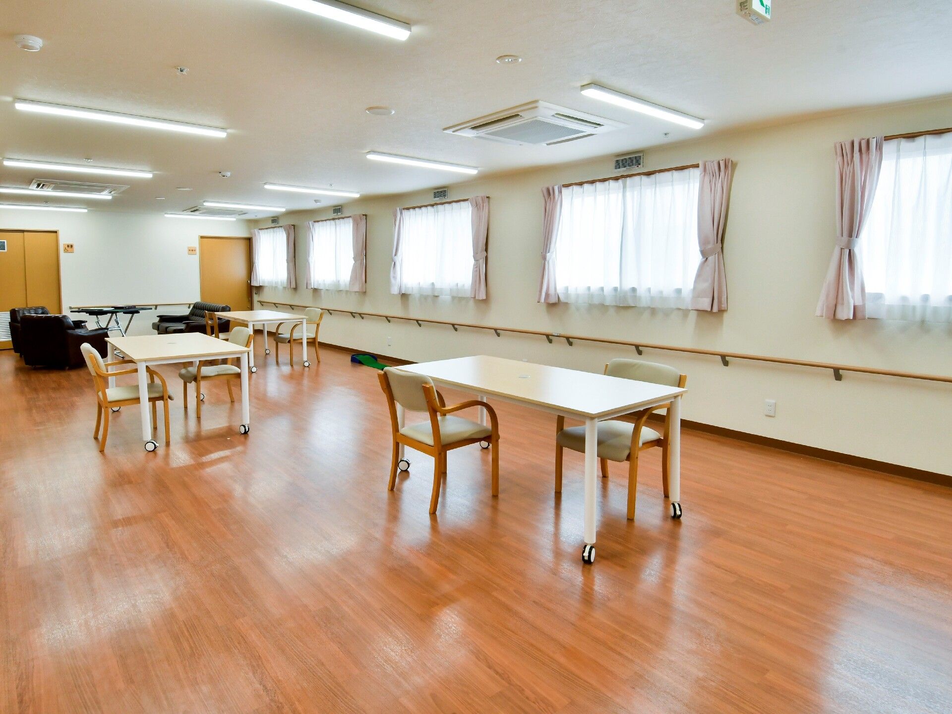 落ち着いたベージュの差し色の柱と扉のある、明るい白基調の壁と天井