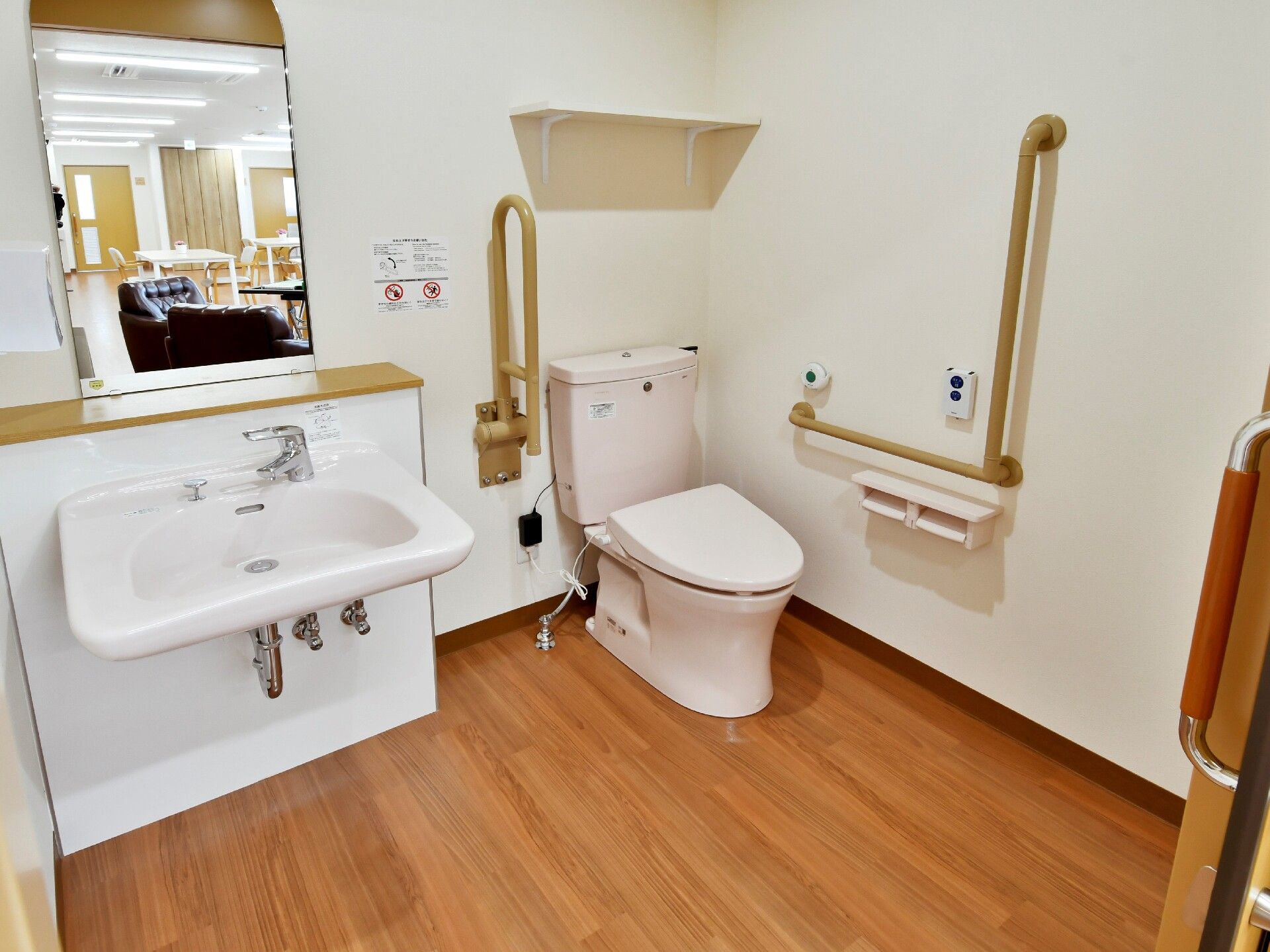 広い空間のトイレには洗面台が用意されているので、便利に使用できる。壁には手すりが備えつけられている。