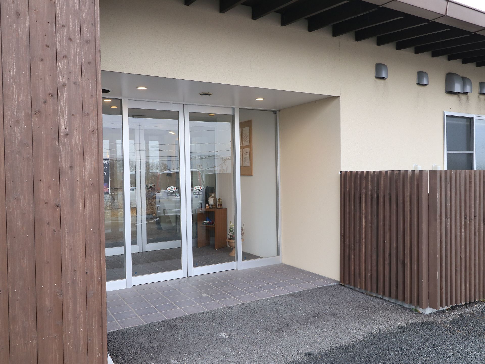 玄関入口は広いスライド式のガラスドアが内玄関と外玄関に設けてある。足元はバリアフリーで内玄関に掲示物が貼ってある。