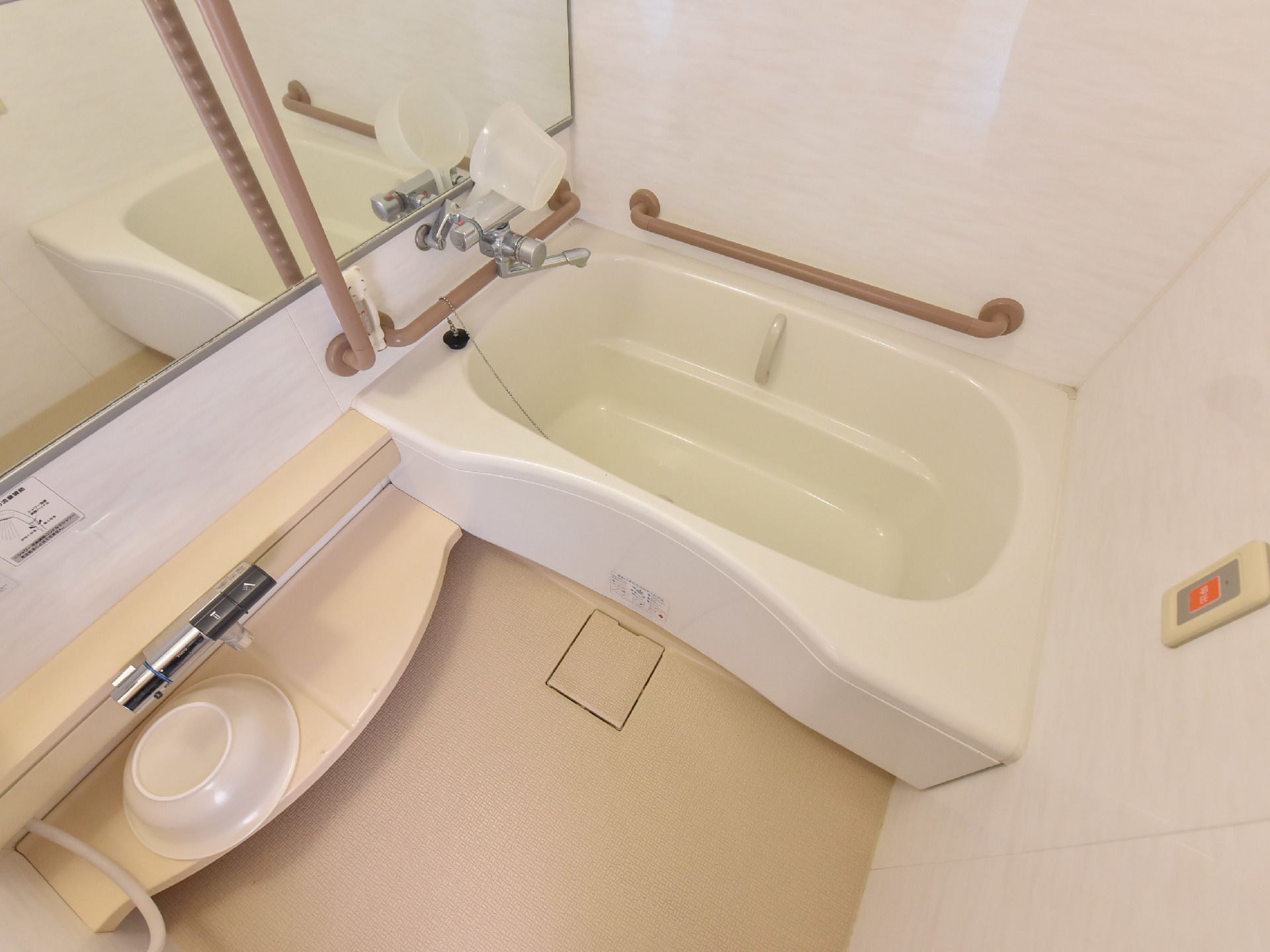 大きな鏡の付いた個浴用の浴室である。浴槽周りに手すりが設置されており、壁に緊急用の呼び出しボタンが付いている。