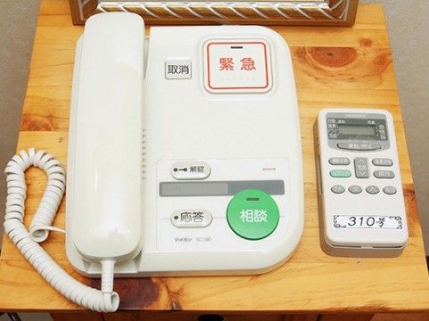 部屋に取り付けられた緊急ボタンが大きく表示された電話