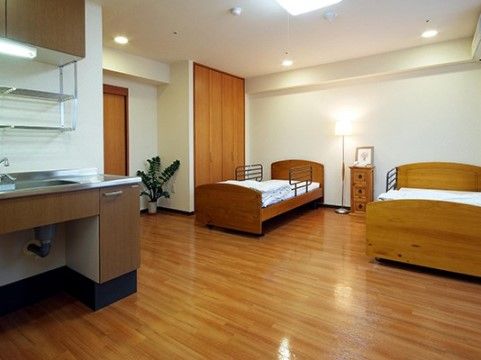 ご夫婦でご入居いただけるお２人部屋もご用意しており、２台のベッドや家具を入れても十分な広さのある、木の風合いが活かされた室内である。