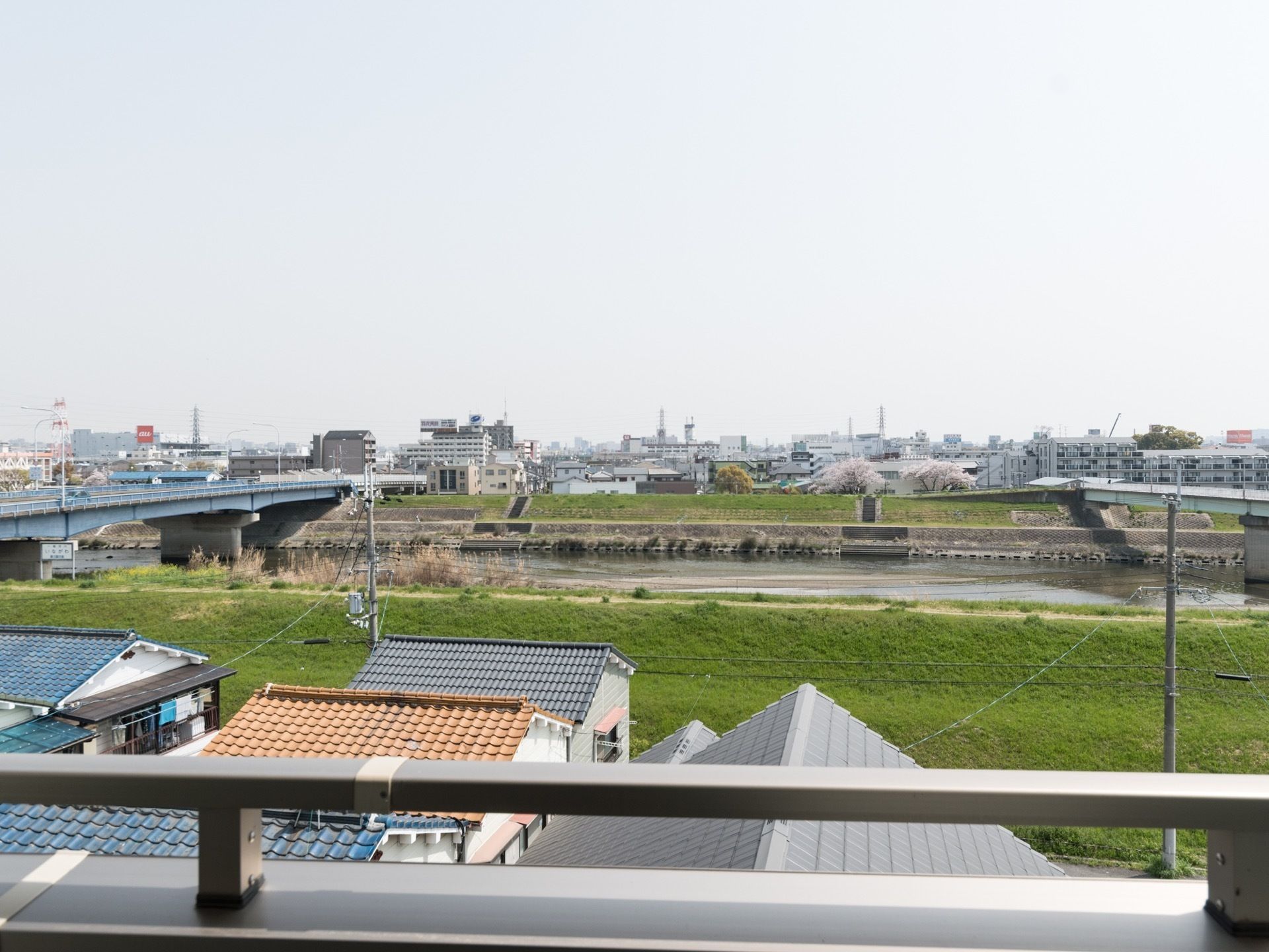 居室のベランダからは猪名川が見える。土手には桜が咲いている。周囲は住宅地であり、公園もある静かな環境である。