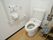 トイレにはお尻洗浄機能がついた、洋式便器を設置している。また壁には操作パネルがあり、手すりが取り付けられている。