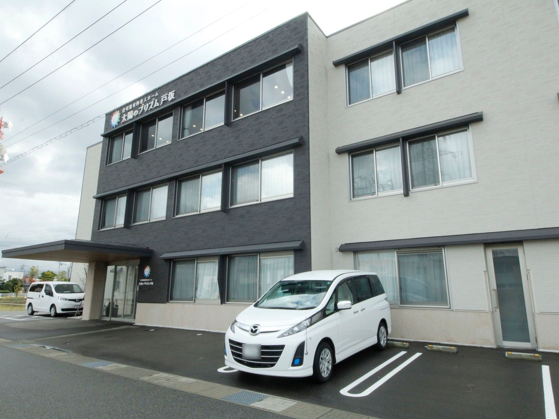 建物は3階建てで、最上階の外壁には大きな文字で施設名が表示されておりわかりやすい。施設前にはたくさんの駐車場が用意されている。