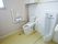 トイレは、広いスペースが確保されている。洋式便器と小便器が並んで設置されており、手すりが壁に備え付けられている。
