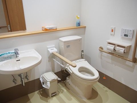 トイレスペースには洋式便座と手洗いがあり、便座の両側に手すりが設置されている。ナースコールが取り付けられている。