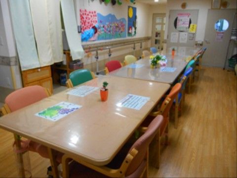 手作りの壁飾りが華やかな、季節感のあるリビングである。温かみのあるカラフルな家具が設置され、入居者様にとって居心地の良い場所となっている。