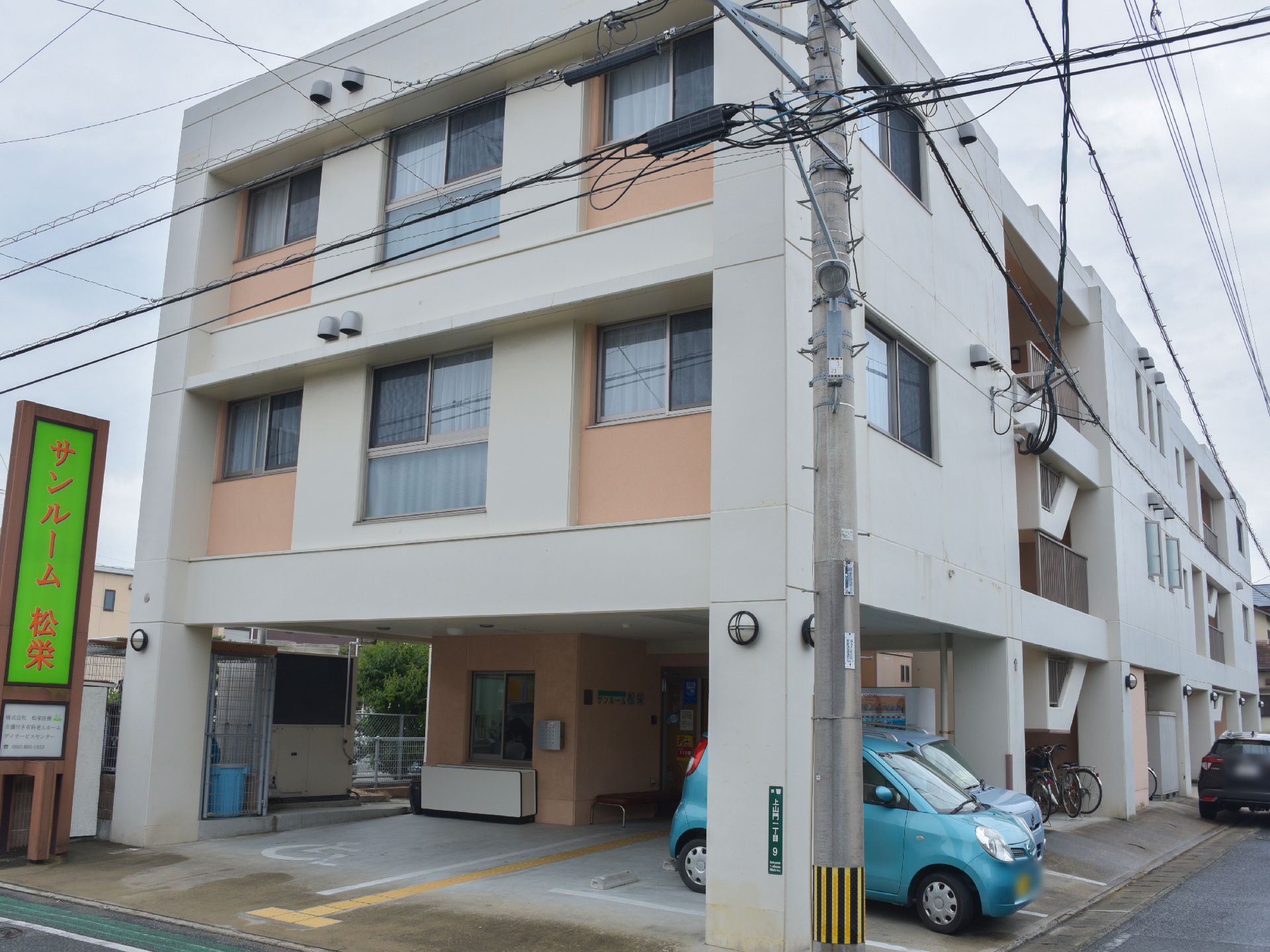 「サンルーム松栄」は、3階建ての建物。小規模入居施設。居室入居者と、デイサービス利用者が来館している。