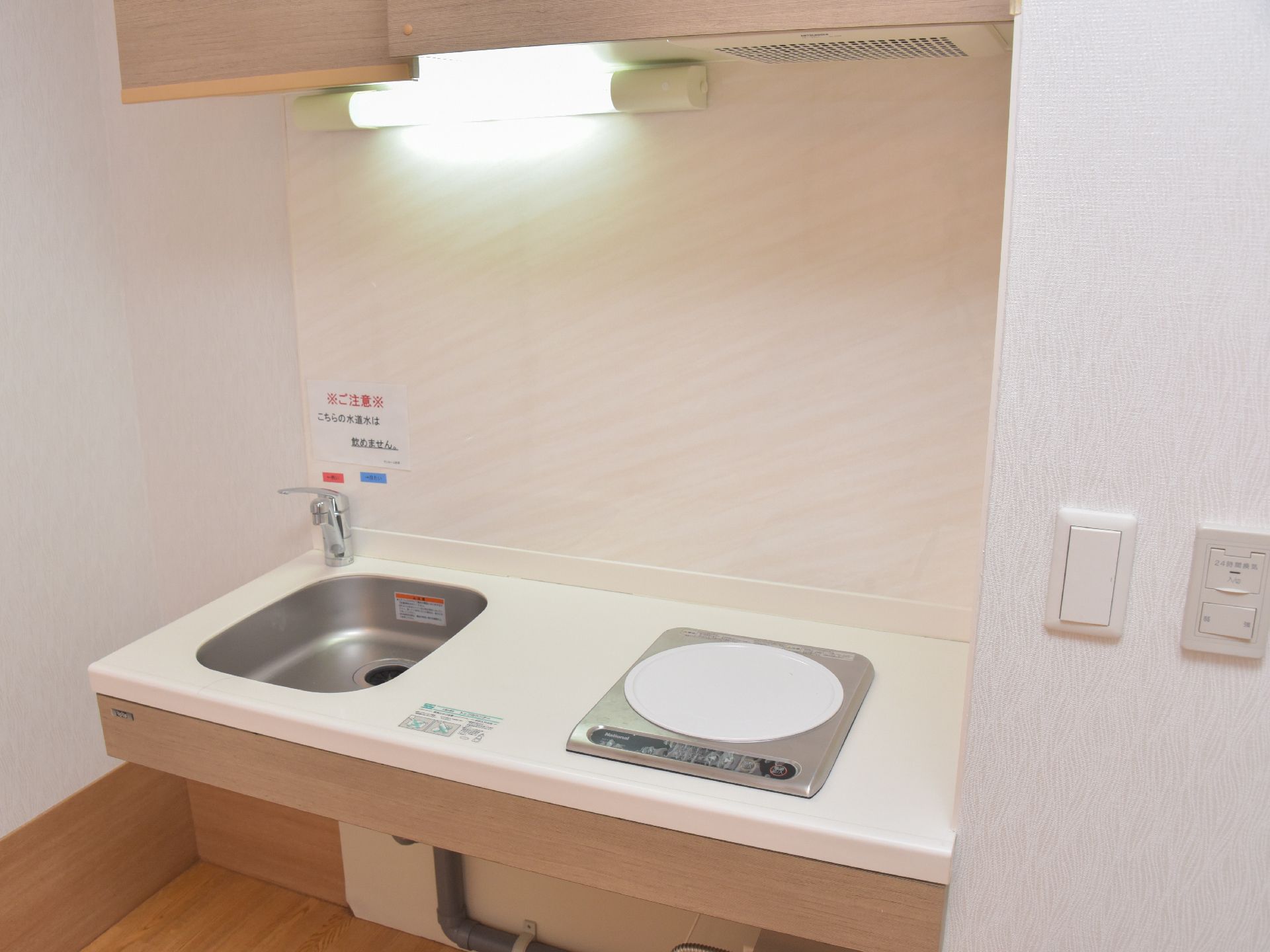 簡易的な調理スペース。小さめのシンクと、その隣に電気コンロがある。ボタンで簡単操作できるので、便利。