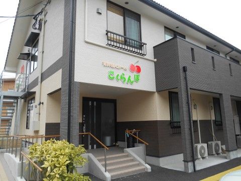 入り口上部に施設名が書かれた外観でグレーと白のツートンの施設