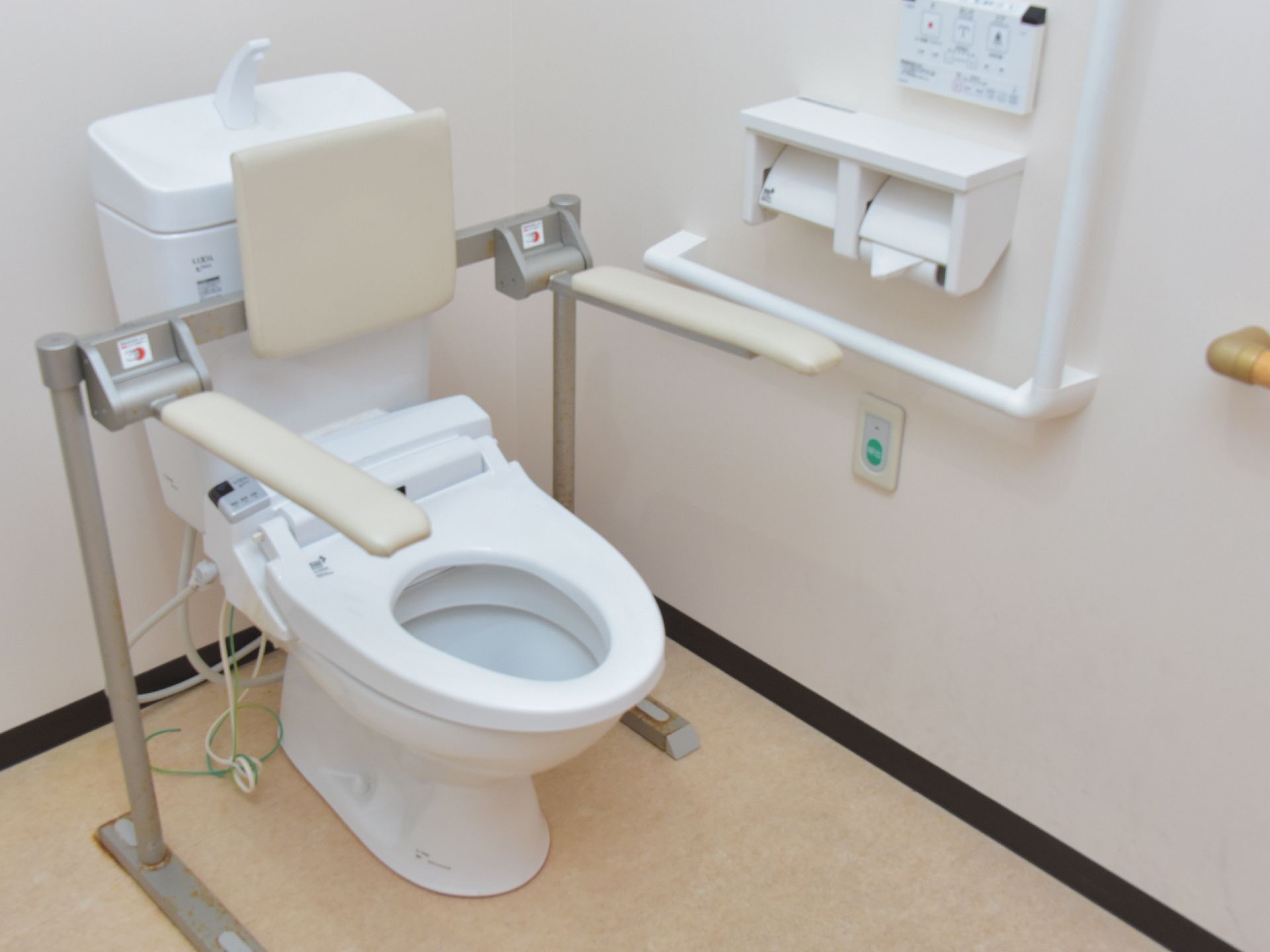 居室内にある、トイレ。生活の状況に合わせ、背もたれと両脇に手すりが付いているタイプの器具を利用できる。